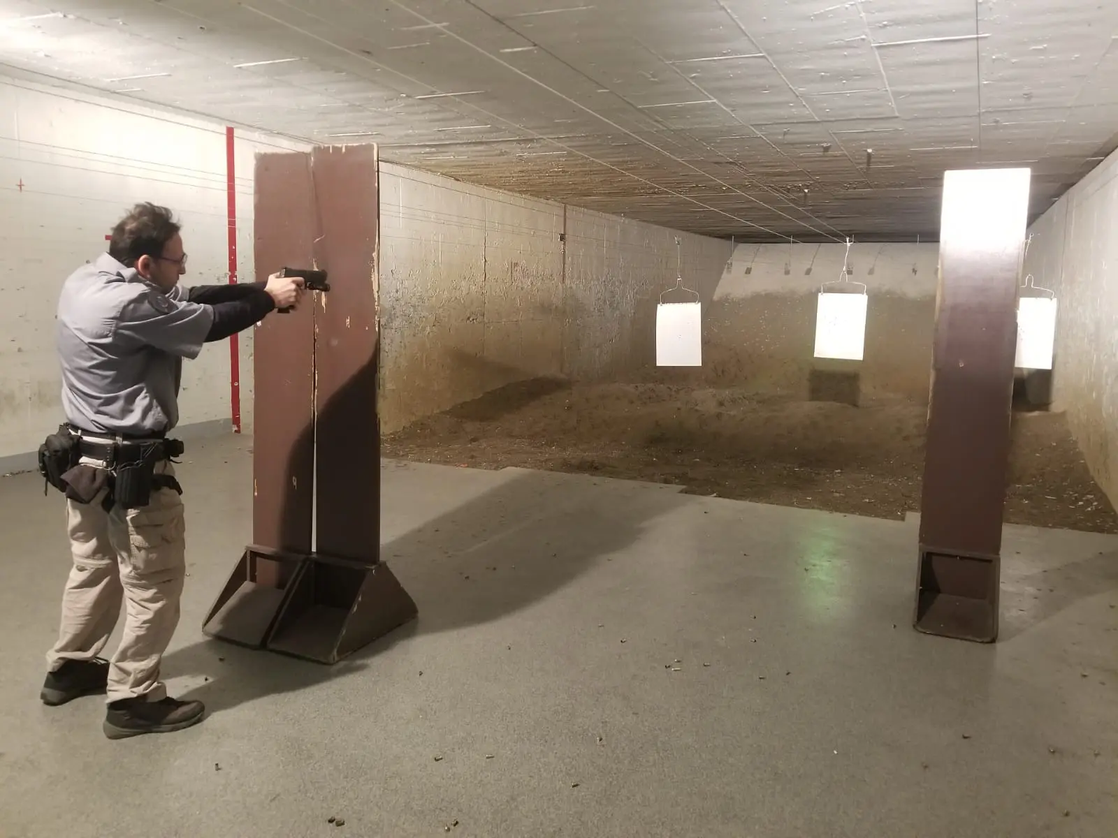 A man is shooting at an indoor target.