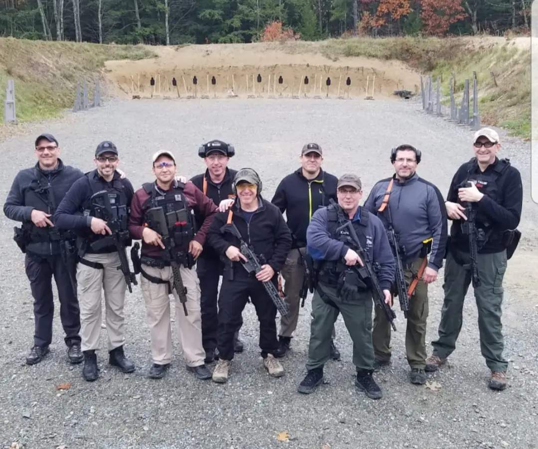 A group of people standing in front of guns.