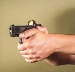 A person holding a gun in their hands.